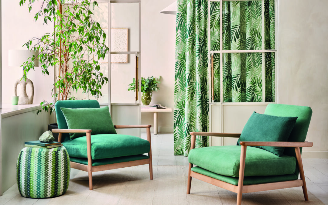Green chairs in a modern living room with tropical patterned curtains